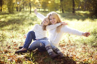 Güzel, mutlu bir anne ve küçük kızı Autumn Park 'ta oynuyorlar..