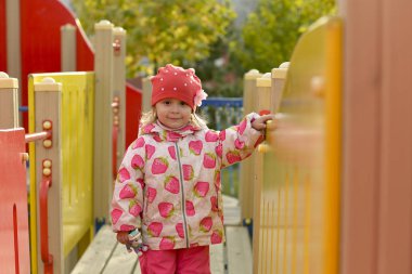 Kırmızı Şapkalı altın sonbaharda Parkta oynayan küçük bir kız.