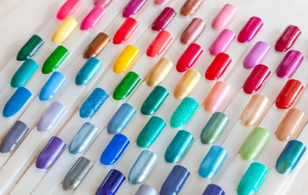 Nail polish colorful samples in rainbow colors. Set of artificial nails. Top view