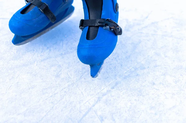 Patas de un patinador de hielo en viejos patines vintage. Hielo skratched fondo — Foto de Stock