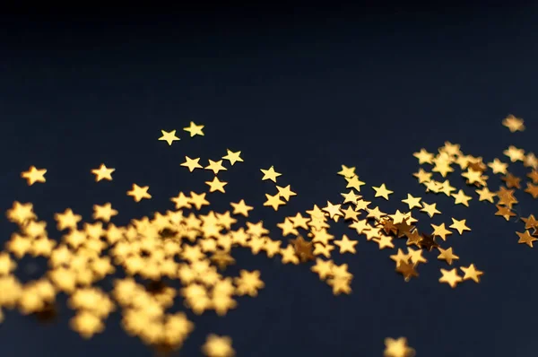 Крошечные золотые звезды на черном фоне, вид сверху, карнавал, приглашение на вечеринку или праздничный фон, звездное ночное небо — стоковое фото