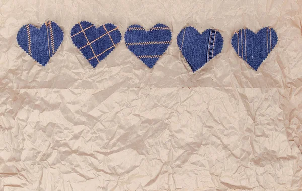 El buruşuk zanaat kağıt arka plan üzerinde Jeans kalpleri yaptı. Düz döşeme, üst görünüm, minimal stil, metin için kopyalama alanı. Aşk sembolü, Sevgililer Günü tebrik kartı veya sosyal medya sonrası için