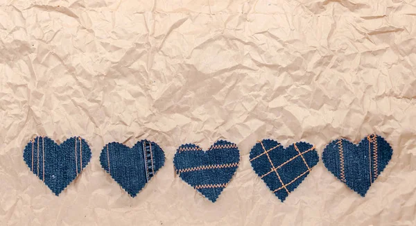El buruşuk zanaat kağıt arka plan üzerinde Jeans kalpleri yaptı. Düz döşeme, üst görünüm, minimal stil, metin için kopyalama alanı. Aşk sembolü, Sevgililer Günü tebrik kartı veya sosyal medya sonrası için