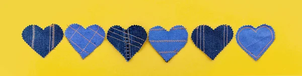 El sarı bir arka plan üzerinde Jeans kalpleri yaptı. Düz döşeme, üst görünüm, minimal stil, metin için kopyalama alanı. Aşk sembolü, Sevgililer Günü tebrik kartı veya sosyal medya sonrası için