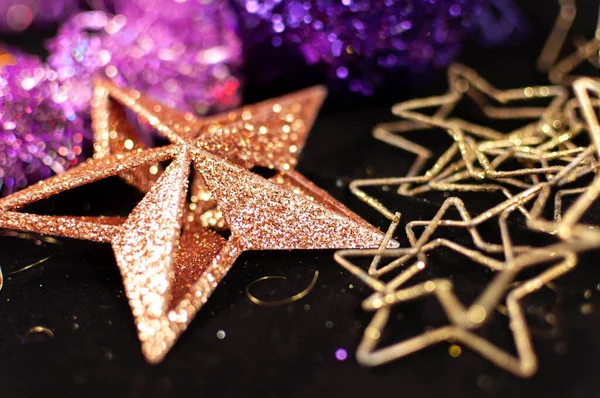 ティンセル、星、ボールなどのクリスマスの装飾がクローズアップ。暗い背景に新年の装飾 — ストック写真