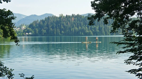 Gyönyörű kilátás a Bledi-tó, emberek, a Júliai-Alpok hegyei, a napsütésben, Bled, Szlovénia — Stock Fotó