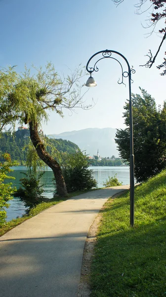 Camino alrededor del lago Bled, las montañas de los Alpes Julianos y el castillo de Bled, mañana soleada, Bled, Eslovenia — Foto de Stock