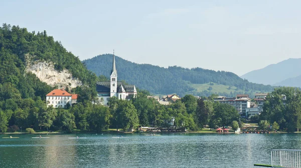 Malerischer Blick auf den See, die Julischen Alpen und die Kirche, sonniger Tag, blutig, Slowenien — Stockfoto