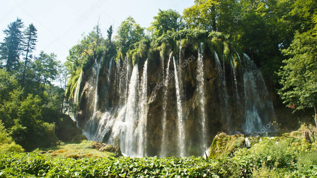 Waterfall and rock, beautiful nature landscape, Plitvice Lakes in Croatia, National Park, sunny day