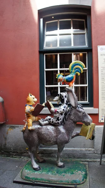 Bremen, Duitsland-07 23 2015-uitzicht op het standbeeld van de stad muzikanten in de middeleeuwse straat Schnoor in het centrum van de Hanzestad, toegang tot restaurant, prachtige architectuur, zonnige dag — Stockfoto
