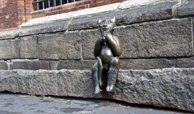 Lubeck, Almanya - 07 26 2015 - St. Marys kilisesinin önünde taş bir basamak üzerinde oturan şeytanHeykeli