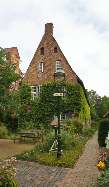 旧市街、ルーベック、ドイツの通りにレンガの家や植物と美しい居心地の良い中庭 — ストック写真