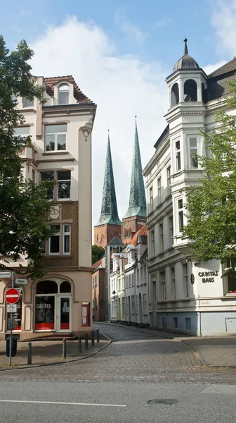 Lubeck, Alemania - 07 26 2015 - Vista de la calle peatonal con casas antiguas y la iglesia en el centro de la ciudad, hermosa arquitectura — Foto de Stock