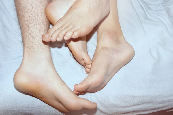 Couple on the bed, crossed legs. Love and relationships