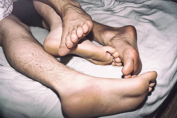 Couple on the bed, crossed legs. Love and relationships