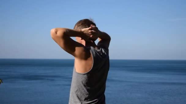 男は海にウォーム アップ運動を行います 新鮮な空気と健康的なライフ スタイル — ストック動画