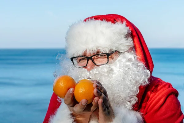 Fet Man Glas Klädd Som Santa Innehar Mandariner Havet — Stockfoto