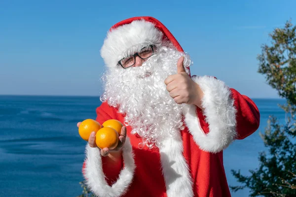 Fet Man Glas Klädd Som Santa Innehar Mandariner Havet — Stockfoto