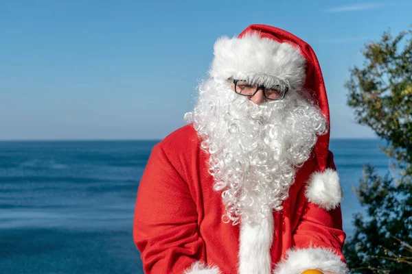 Hombre Gordo Gafas Vestido Como Santa Sostiene Mandarinas Océano —  Fotos de Stock