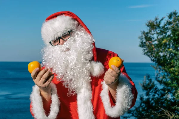 Gruby Mężczyzna Okularach Ubrany Jak Santa Posiada Mandarynki Oceanie — Zdjęcie stockowe