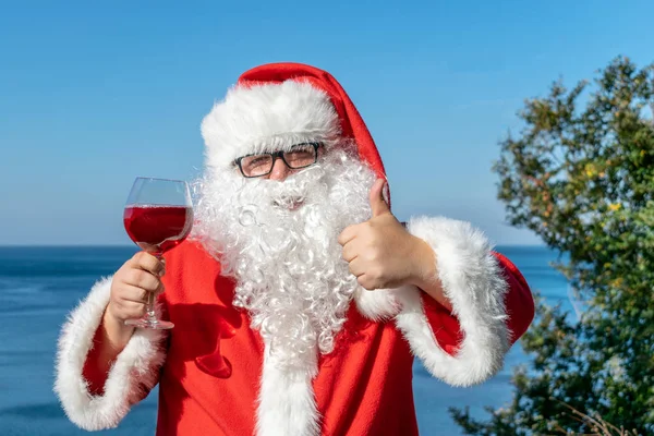 Fet Man Glas Klädd Som Santa Dricker Vin Havet — Stockfoto