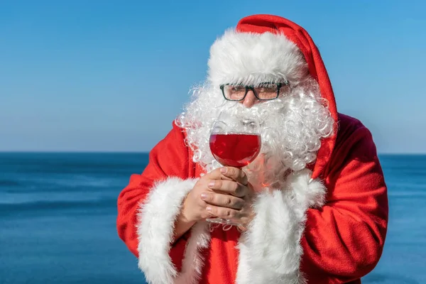 Gruby Mężczyzna Okularach Stroju Świętego Mikołaja Picie Wina Oceanie — Zdjęcie stockowe