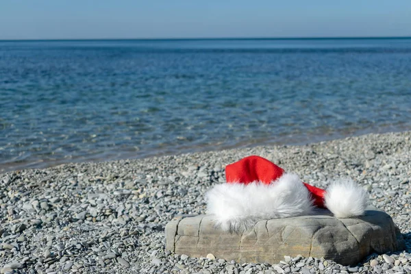 Egy Nagy Tengerparton Fekszik Santa Claus Kalap — Stock Fotó