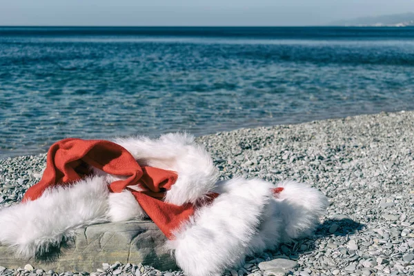 Santa Claus Ubrania Kapelusz Leży Dużych Kamieni Brzegu Morza — Zdjęcie stockowe