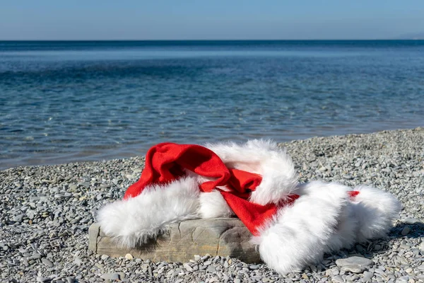 Santa Claus Ubrania Kapelusz Leży Dużych Kamieni Brzegu Morza — Zdjęcie stockowe