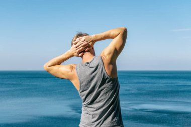 Okyanusun bir ısınma egzersiz yapan erkek.