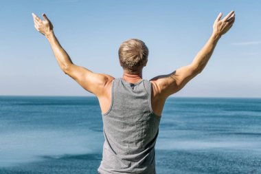 Okyanusun bir ısınma egzersiz yapan erkek.