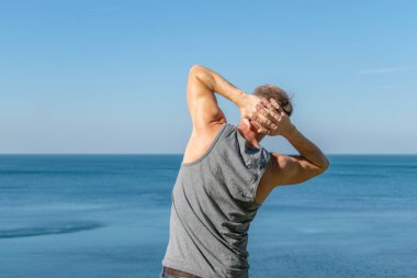 Okyanusun bir ısınma egzersiz yapan erkek.