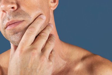 Üzgün depresif adam yanağını tutarak acı içinde. Mavi arka plan üzerinde bir adam portresi. duygu yüz ifadesi. duygu ve insanlar tepki. Diş ağrısı