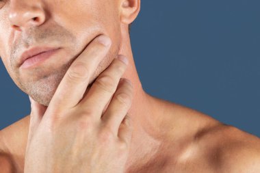 Üzgün depresif adam yanağını tutarak acı içinde. Mavi arka plan üzerinde bir adam portresi. duygu yüz ifadesi. duygu ve insanlar tepki. Diş ağrısı