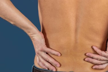 Onun acı iltihaplı bel mavi arka plan üzerinde tutan adam. Sağlık ve Tıp. Sırt ağrısı acı