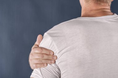 Ağrı gidermek çalışan ağrıyor omzunun tutan adam