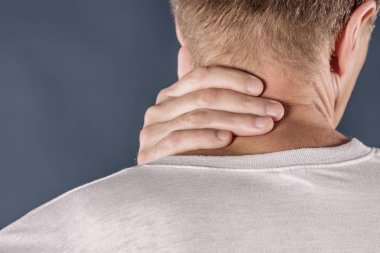 Ağrı gidermek çalışırken boynunu tutan adam