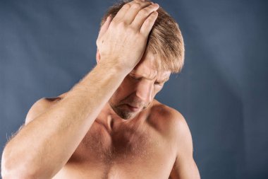 Bir adam mavi zemin üzerine kafasında onun ellerini tutar