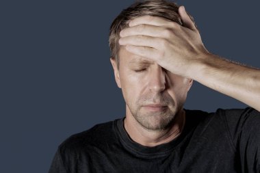 Bir adam mavi zemin üzerine kafasında onun ellerini tutar