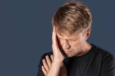 Bir adam mavi zemin üzerine kafasında onun ellerini tutar