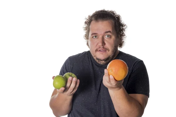 Hombre gordo divertido sostiene frutas sobre fondo blanco. Pérdida de peso y alimentación saludable — Foto de Stock