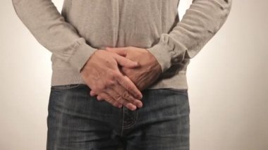 Onun üretra acı içinde tutan adam. Üretra ağrı beyaz arka plan üzerinde deneyim adam