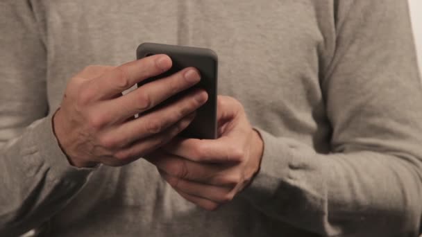 Ο άνθρωπος στο πουλόβερ κουβεντιάσει στο τηλέφωνο σε άσπρο φόντο. Άνθρωποι και communoication — Αρχείο Βίντεο