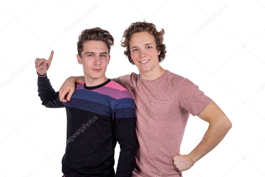 Portrait of a two happy young men pointing fingers isolated