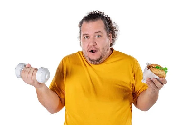 Смешной толстяк ест нездоровую пищу и пытается выполнять упражнения изолированы на белом фоне — стоковое фото