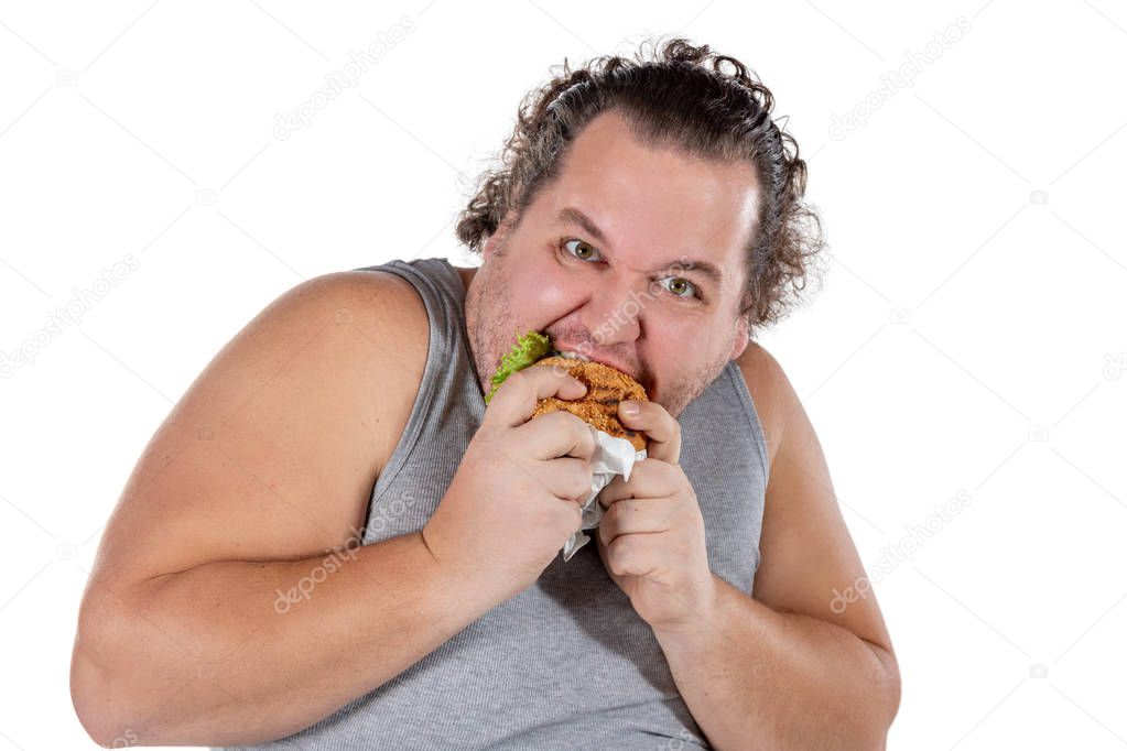 Portrait of funny fat man eating fast food burger isolated