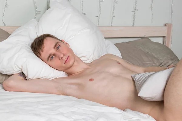 Schöner junger erwachsener Mann, der im Bett schläft. sexy nackter Kerl ruht sich aus — Stockfoto