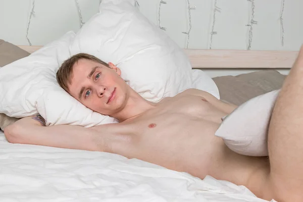 Schöner junger erwachsener Mann, der im Bett schläft. sexy nackter Kerl ruht sich aus — Stockfoto