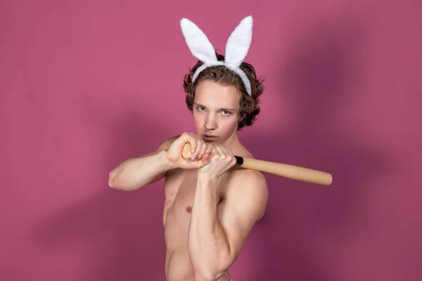 Srandovní chlapík na králíčku s baseballovou pálkou na růžovém pozadí — Stock fotografie
