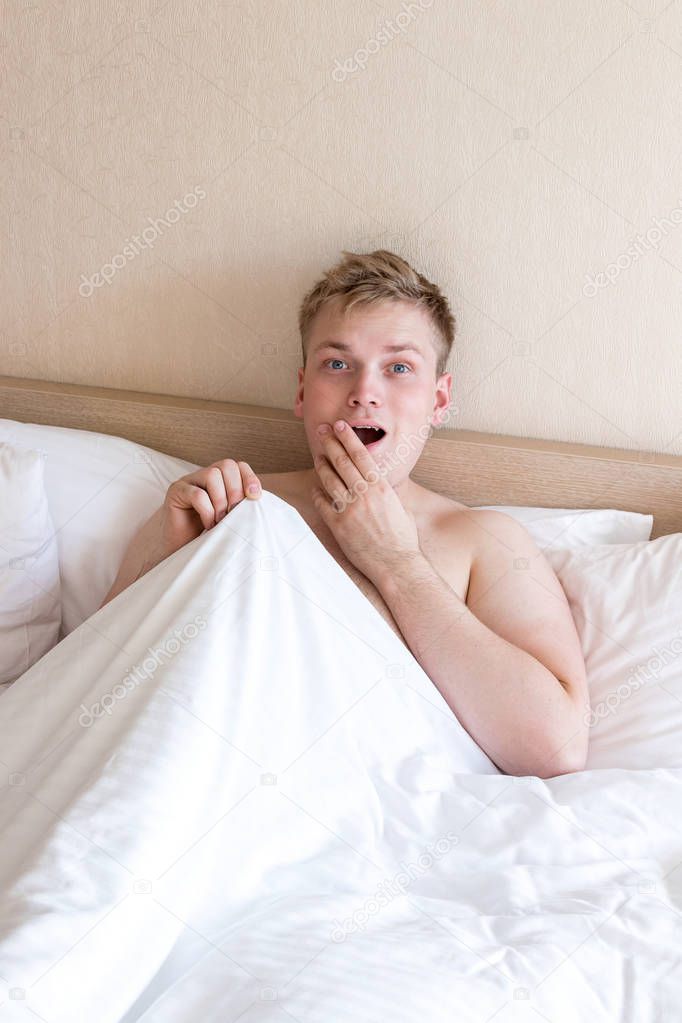 Funny guy in bed under the blanket after sleeping. Sexual problems